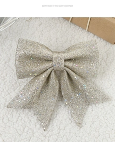 Close-up of golden glitter bow decoration with sequins on cozy white textured background