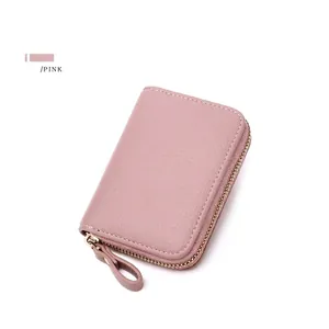 Detailed view of pink leather RFID card holder with pebble grain texture and U-zipper