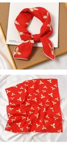 Close-up of a red cotton linen scarf with white floral patterns on silk background