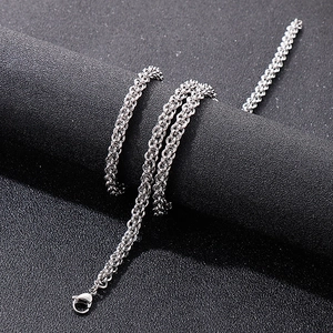 Close-up of a silver stainless steel interlocking chain with spring clasp on black texture