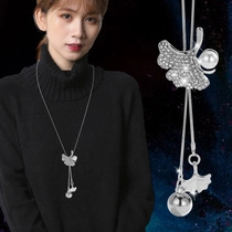 Detail of ginkgo leaf sweater chain with rhinestones and pearl on black knitwear