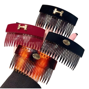 Set of four vintage acrylic H-letter hair combs in black, burgundy, and tortoiseshell finish