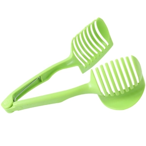 Green plastic lemon and tomato slicer tool with spring handle on white background