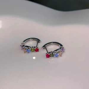 Detailed macro view of rainbow cubic zirconia stones on silver hoop earrings