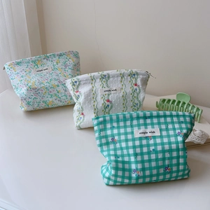 Three floral and plaid cotton makeup bags with simple wish labels and metal zippers