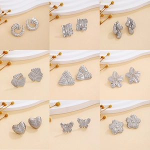 Silver textured earring collection including heart, butterfly, and geometric metal studs