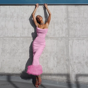 Detail shot of chic pink strapless midi dress featuring elegant feather hem trim