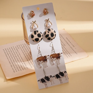 Detailed view of 5-pair earring set featuring heart, cross, and cow print charms