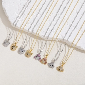 Close-up of animal pendant necklaces with micro-pave zircons on a white textured stone