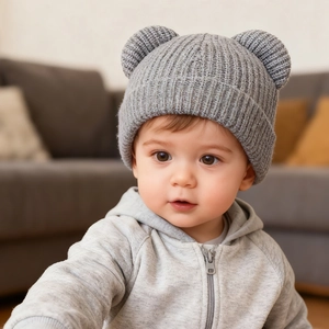 Detailed close-up of gray knitted baby hat featuring cute bear ears and soft wool texture