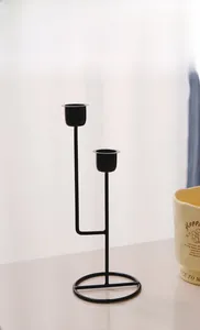 Close-up of minimalist black matte metal candle holder with dual cup-style heads