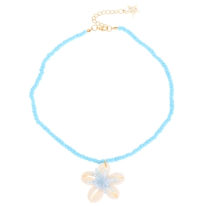 Dettaglio della collana boho con perline blu, pendente a fiore di conchiglia e ciondolo stella