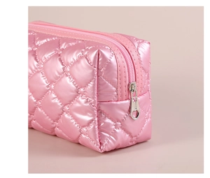 Close-up of pink quilted makeup bag featuring heart-shaped silver metal zipper pull