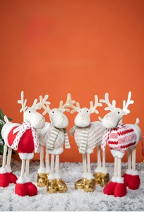 Detailed close-up of plush Christmas reindeer dolls in varied knit sweater patterns