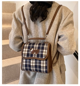 Detail of retro plaid backpack with dachshund embroidery worn on a grey suit jacket