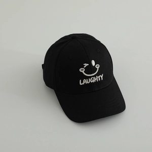 Detailed close-up of a black cotton baseball cap with white wink face embroidery