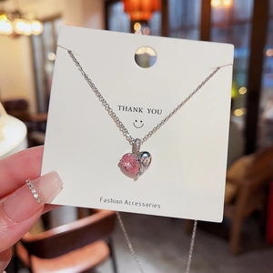 Détail d'un pendentif coeur en cristal rose sur une chaîne de couleur argent