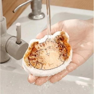 Cartoon cat shaped wood pulp cotton sponge being rinsed under water faucet