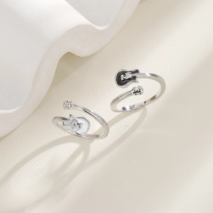Detail view of silver rings featuring black and white guitar designs with small diamonds