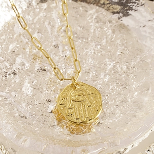 Collier Main de Fatima doré avec chaîne trombone et pendentif aux textures géométriques