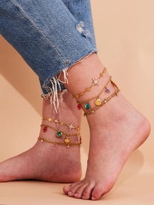 Nahaufnahme der goldenen mehrlagigen Fußkette mit Seesternen und Muscheln an einem Modell