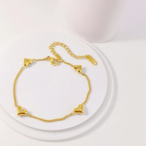 Close-up of gold heart bracelet with zircon stones, lobster clasp and adjustable chain