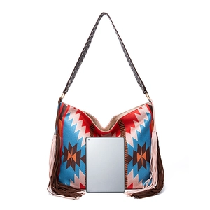 Detail view of large bohemian woven tote bag featuring geometric patterns and side tassels