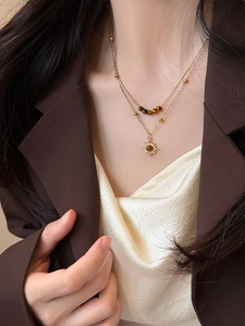 Detail of a double-layered gold sunflower necklace with tiger eye stone beads for women