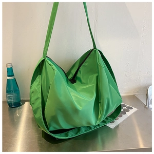 Close-up of a green large capacity oxford nylon shoulder bag on a metal table
