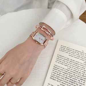 Detail of rose gold rectangular watch with a sparkling diamond geometric bracelet set