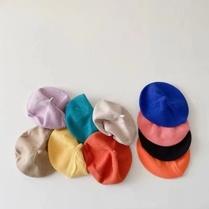 Flat lay of colorful knit baby beret hats for autumn in multiple vibrant shades