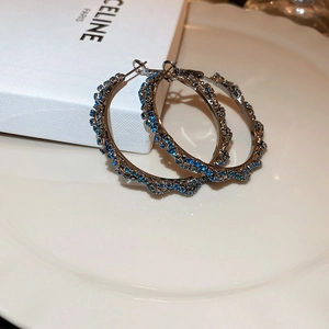 Macro shot of retro dark silver hoop earrings with shimmering dark blue rhinestones