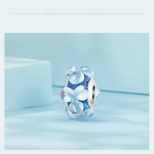 Macro detail of sky blue glass flower bead charm with S925 silver core for DIY jewelry