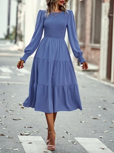 Détails d'une robe trapèze bleue à manches longues avec corsage élastique et poignets à volants