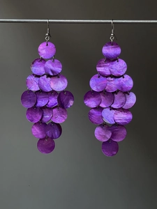 Detailed macro view of purple layered shell discs and long bohemian tassel earrings