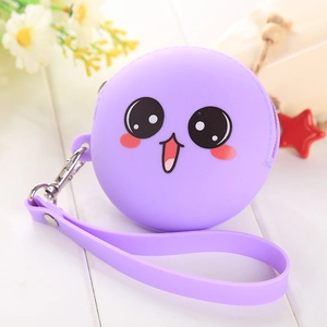 Detail of purple silicone coin purse with cute cartoon face and wrist strap on white wood