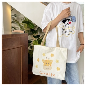Close-up of a large capacity cream canvas bag with a cute giraffe print and yellow flowers