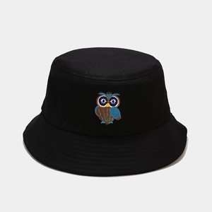 Detailed close-up of colorful owl embroidery on a black cotton canvas bucket hat
