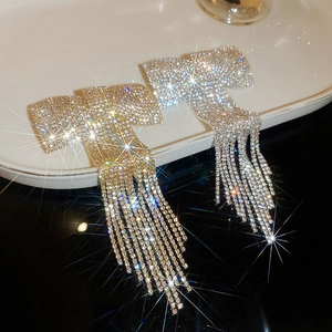 Détail d'une barrette à nœud strass brillant avec pampilles pendantes en or et en argent