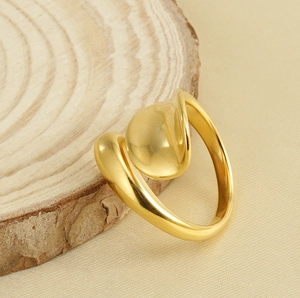 Detailed view of a sleek 18k gold-plated stainless steel ring on a rustic wood slice