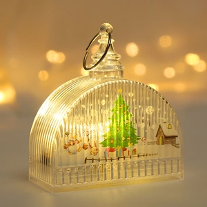 Detail of Christmas lantern with LED light featuring snowman and tree scene inside