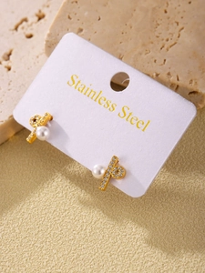 Close-up of gold stainless steel stud earrings featuring pearls and sparkling zircon stones