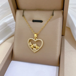 Macro view of gold heart pendant with cubic zirconia inlay on a premium silk display