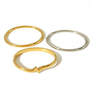 Three minimalist 18k gold and silver stainless steel adjustable bangles on white backdrop