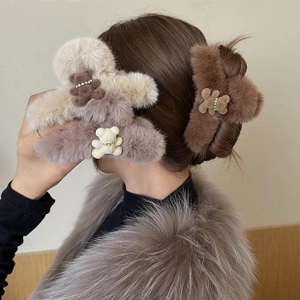 Three plush teddy bear hair clips in beige and brown colors shown on model side profile
