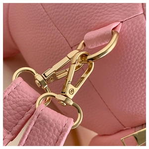 Detail of pink lychee leather backpack with glossy gold metal buckle and fine stitching