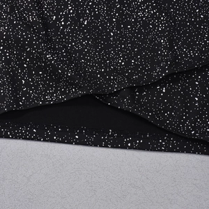 Detailed view of black fabric with white polka dots showing fine stitching and texture