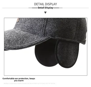 Detail of dark grey herringbone wool baseball cap with foldable ear flaps for winter warmth