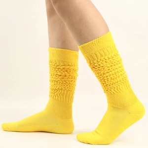 Detail of bright yellow slouch socks featuring a thick textured knit pattern on the leg