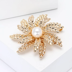 Elegant gold wheat leaf and pearl flower brooch for women displayed on white stand